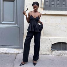 Influencer Sylvie wears a pair of black pants with a black peplum top. She wears a pair of black pointed-toe kitten heels. 