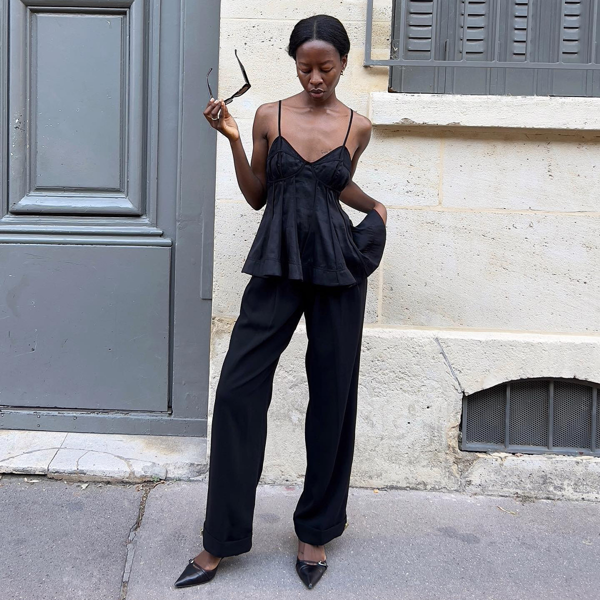 Influencer Sylvie wears a pair of black pants with a black peplum top. She wears a pair of black pointed-toe kitten heels. 