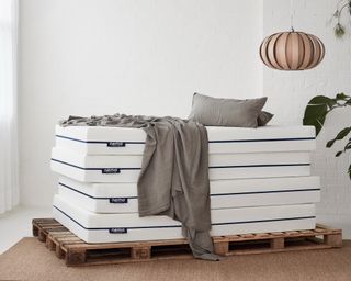 The Millbrook Bed Company Nemo mattresses piled high on a wooden pallet