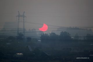 Photographer and skywatcher Svetlana Kulkova snapped this view of the partial solar eclipse of June 1-2, 2011 just after sunrise on June 2 from Bratsk, Russia. The partial solar eclipse was dubbed a