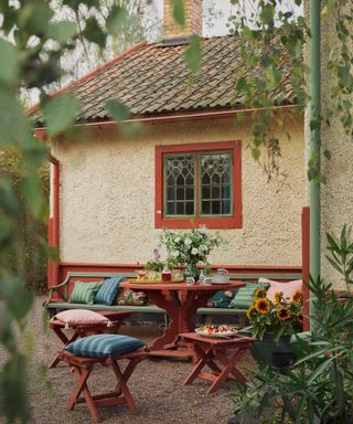 cozy garden round table painted red with eclectic throw pillows and blankets