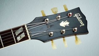 This bound rosewood fretboard features double-parallelogram mother-of-pearl inlays, logo and crown mother-of- pearl headstock inlays, with a black-on-white laminated bell truss rod cover (from 1958)