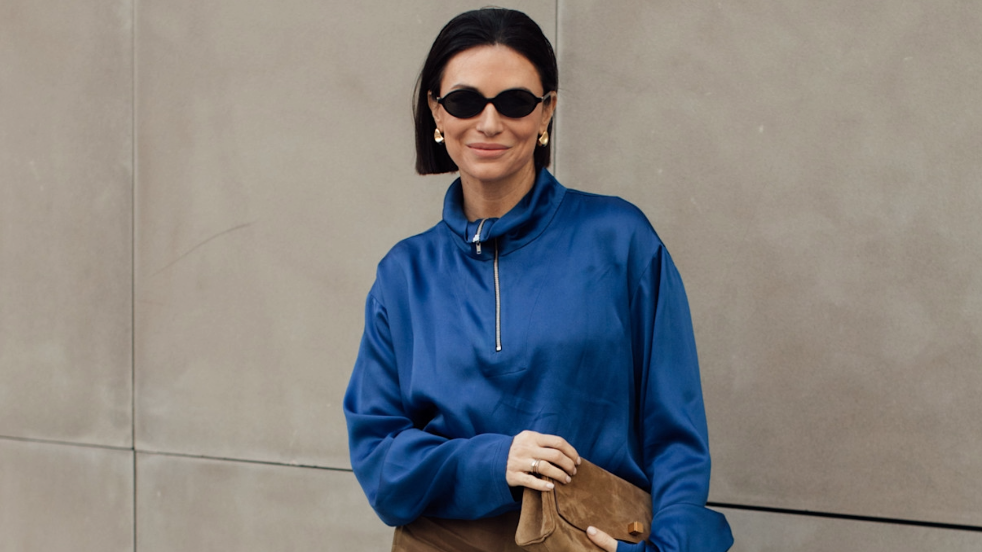 woman wearing a blue jacket and tan skirt. 