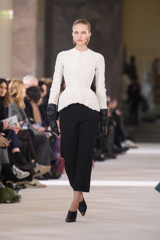 Woman on runway in Schiaparelli white bodice and trousers