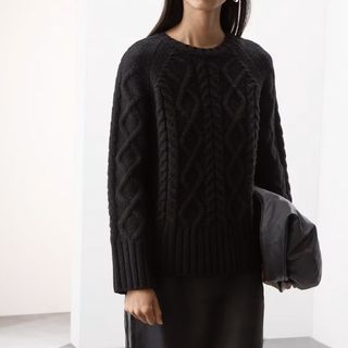 Image of woman wearing black knitted jumper 