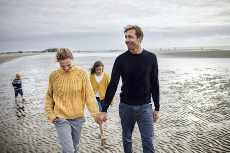 a family of four strolling on the beach 