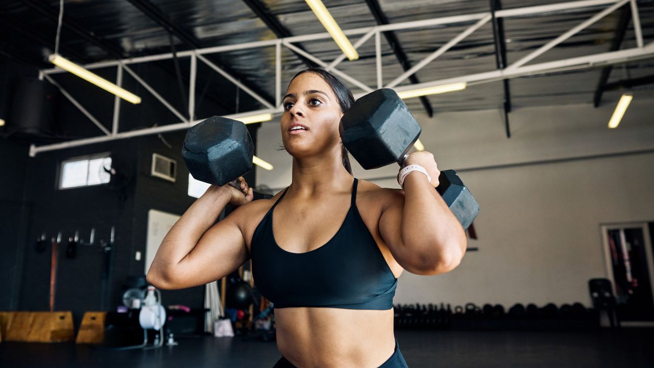 A woman doing dumbbell shoulder press