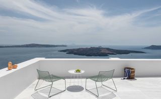 Table & chairs overlook islands in the Mediterranean sea