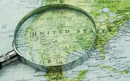 A shot of magnifier glass over map. Looking, searching, research information and traveling