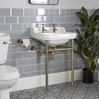 Grey bathroom with traditional brass and white washstand sink