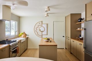 a beige small kitchen with geometric wall art