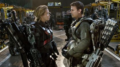 A still from the movie Edge of Tomorrow showing Emily Blunt and Tom Cruise's characters dressed in huge mech suits.