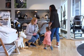 A woman and her daughter trade in a pushchair at Mamas & Papas