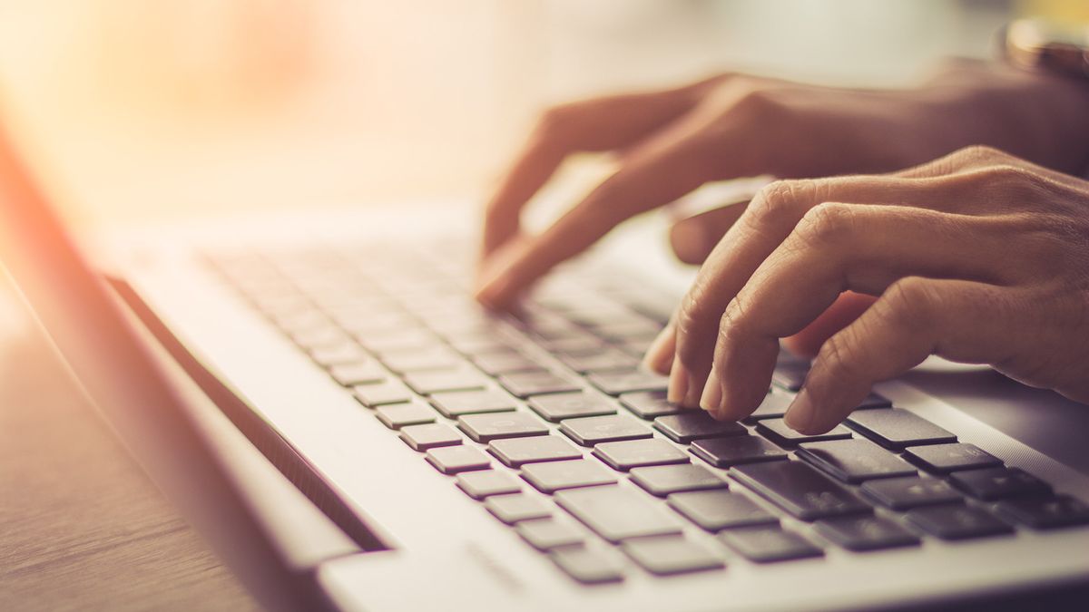 A women&#039;s hands typing on a laptop keyboard