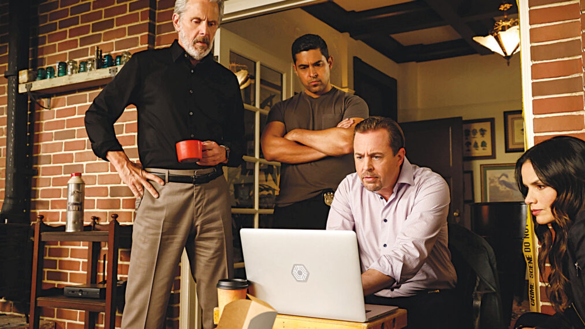 The NCIS team gather round a laptop in NCIS season 23, part 2