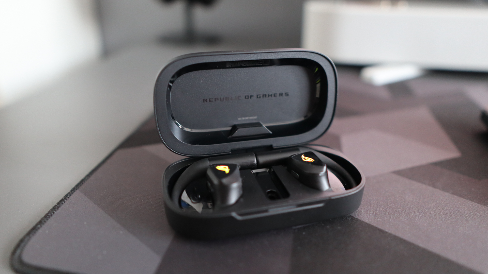 Asus ROG Cetra Open earbuds on a deskmat.