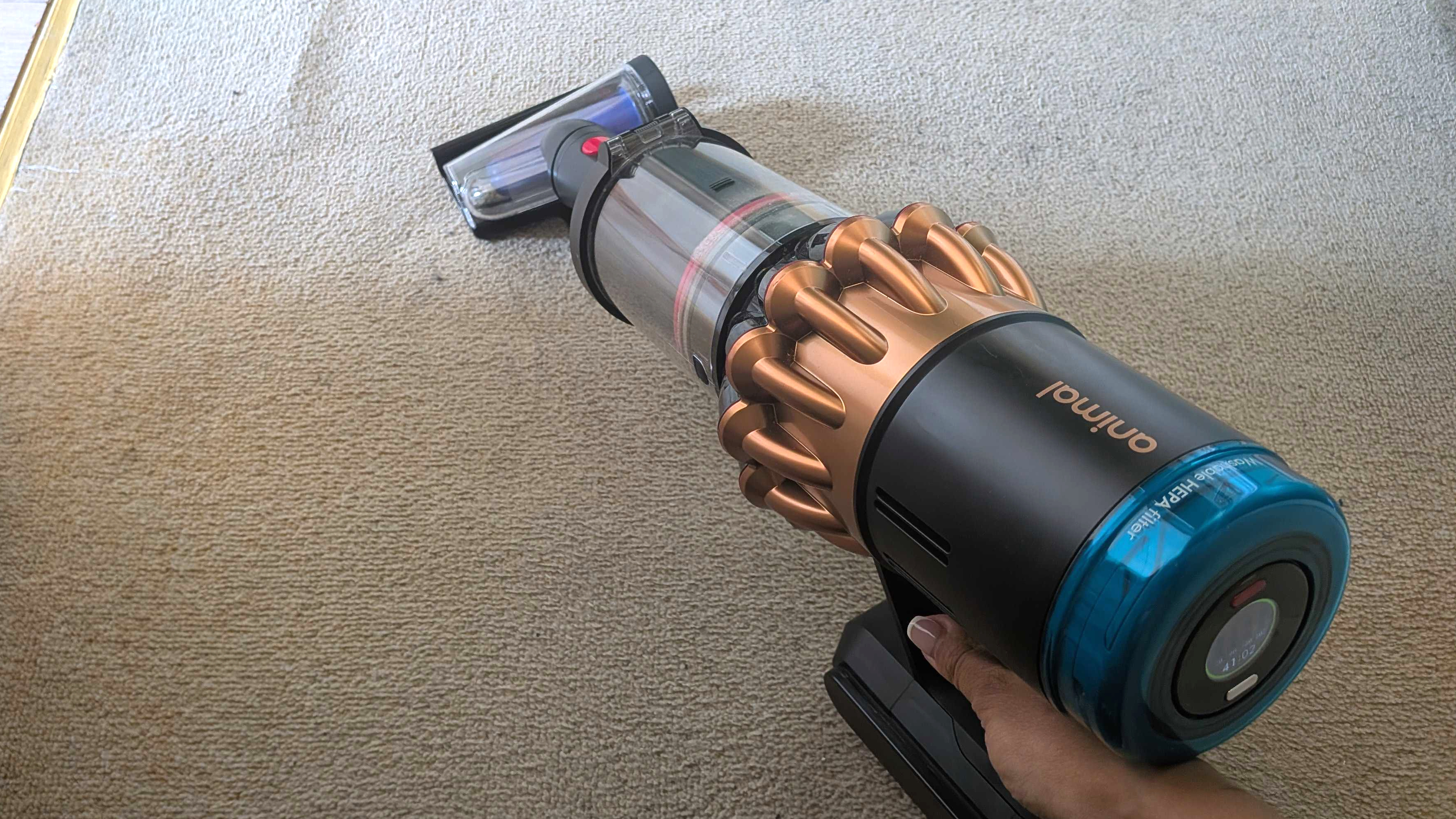 Dyson V16 Animal Piston using screw tool to clean beige carpet
