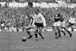 Tottenham's Cliff Jones breaks away from three Nottingham Forest players during a match in 1963.