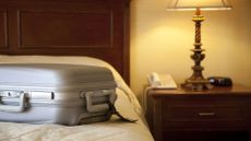 A suitcase on top of a mattress in a hotel room