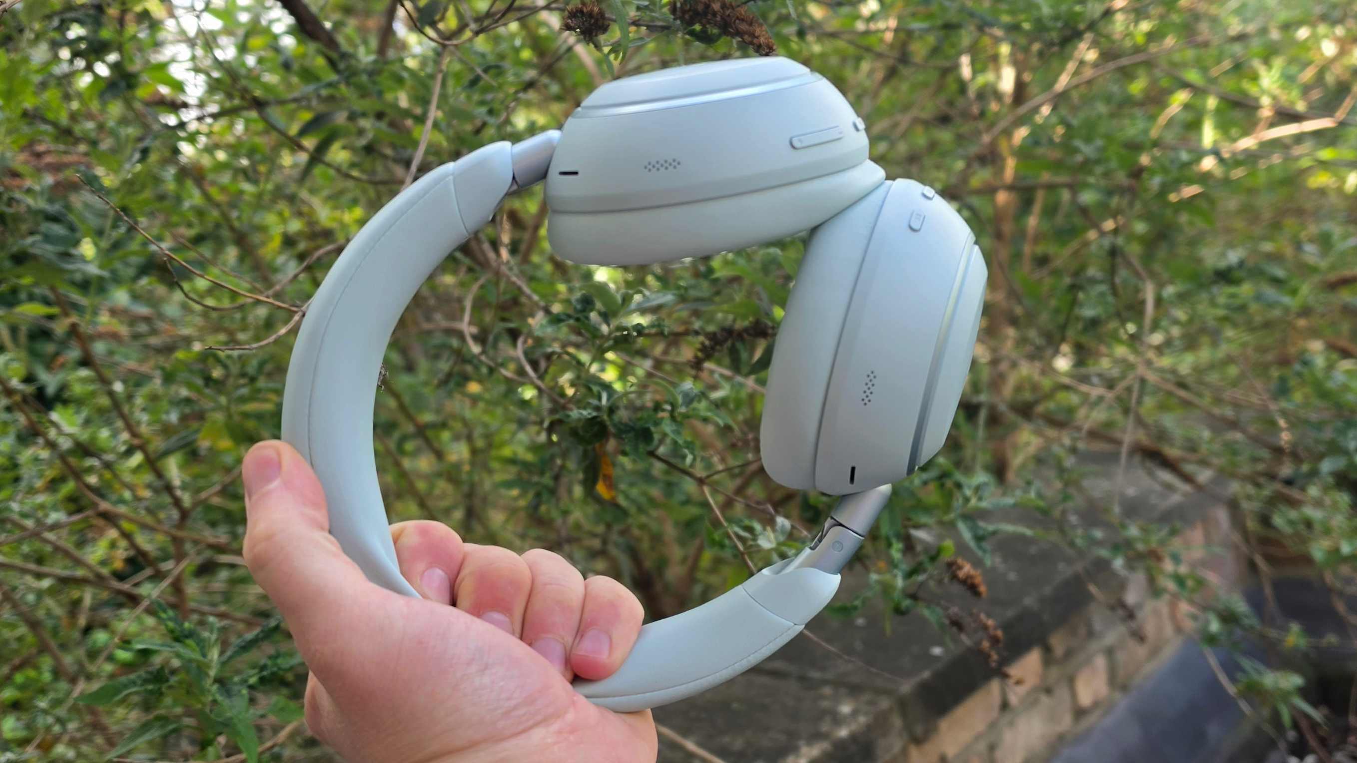 The Soundcore Space 2 in front of a green bush.