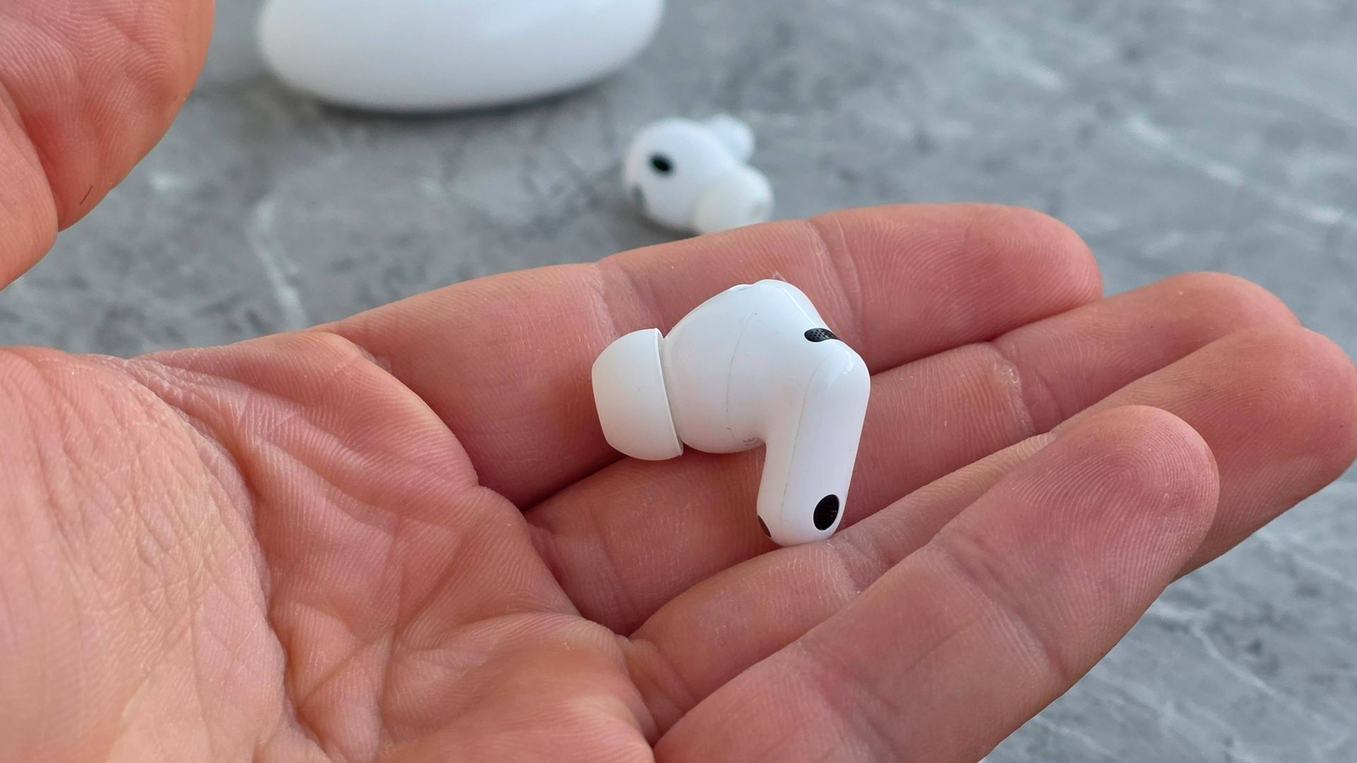 The Huawei FreeBuds Neo bud in a man's hand.