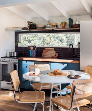 open plan kitchen with blue cabinets and round table