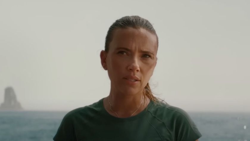 Scarlett Johansson looking skeptically at someone off screen in Jurassic World Rebirth near a large body of water.