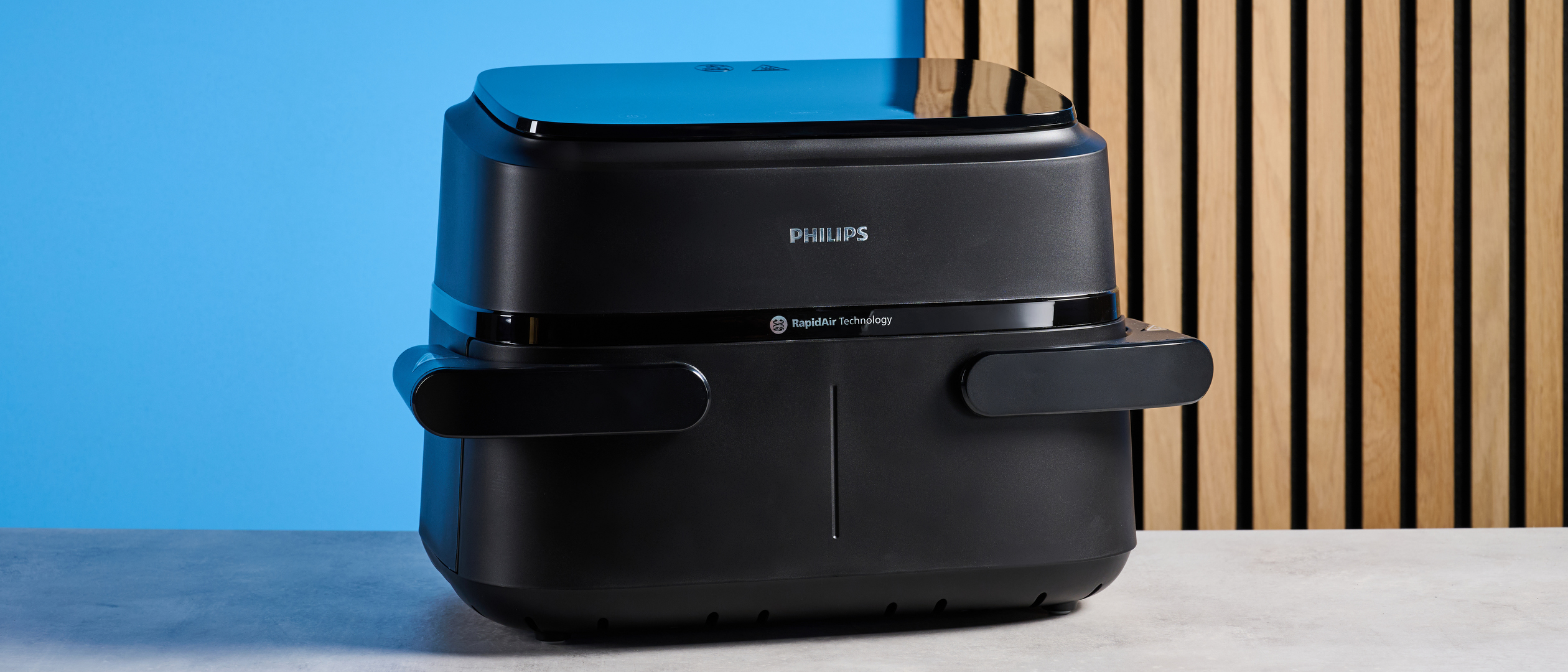 The Philips 1000 Series FlexDrawer Air Fryer photographed in front of a blue background. 