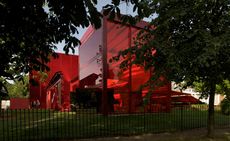 Red, glass-fronted building on grass