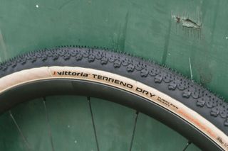 A tan gravel tyre against a green wall