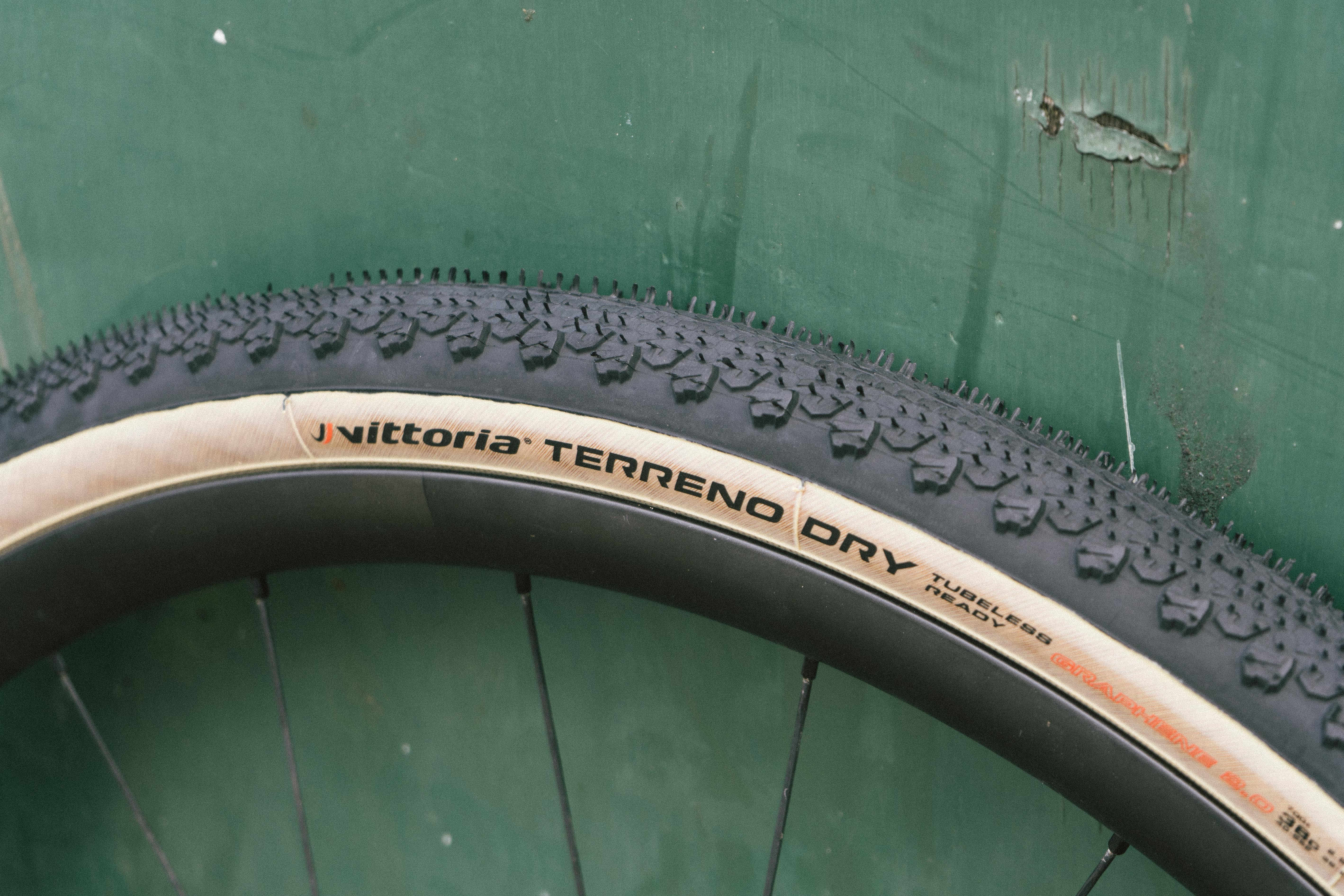 A tan gravel tyre against a green wall