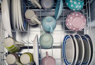 Dishwasher filled with crockery and mugs