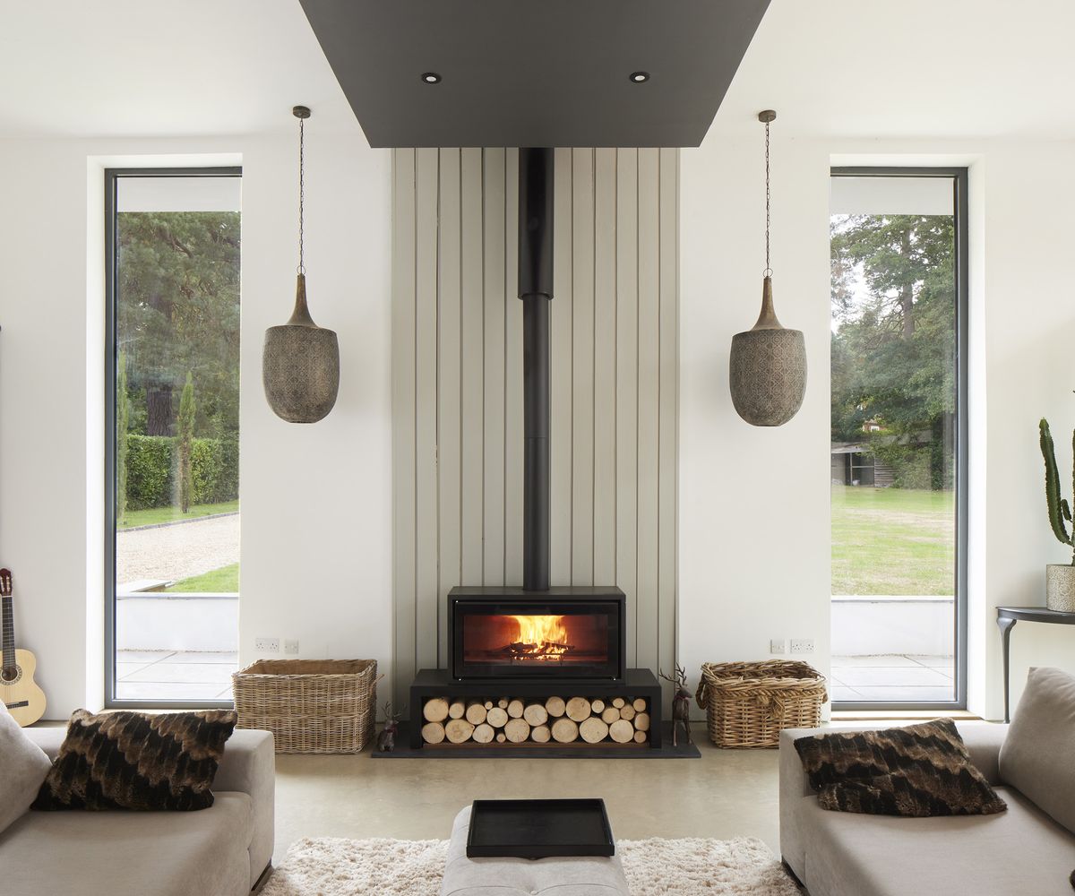 A fireplace with built in log storage in the centre of a new build home