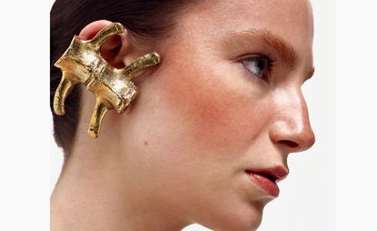 Woman wearing oversized gold earring