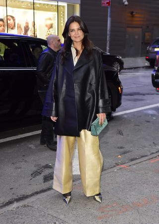 Katie Holmes wearing an oversized leather jacket, wide-leg pants and boots