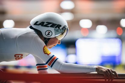 Katie Archibald riding inside a velodrome wearing GB kit