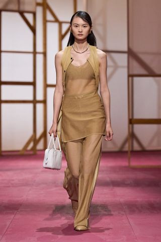 Hermès model at the S/S 25 runway show in Paris wearing a camel-colored monochrome look.