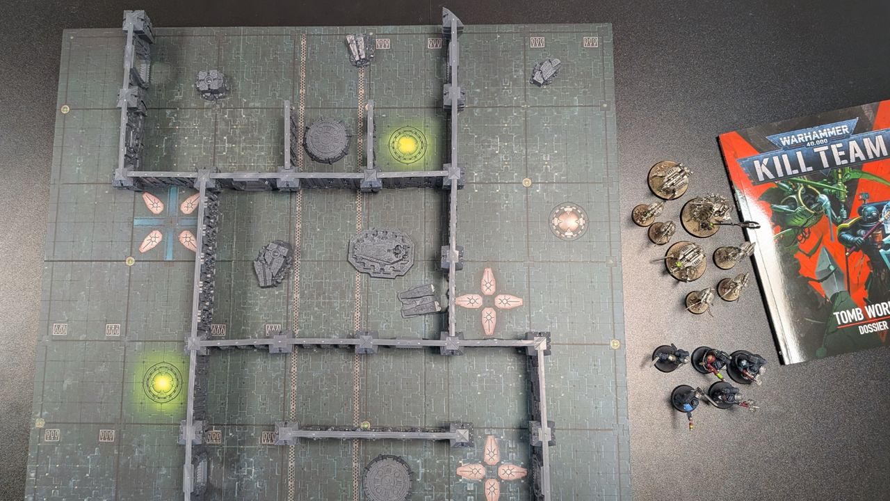Kill Team: Tomb World board, terrain, miniatures, and book on a dark surface