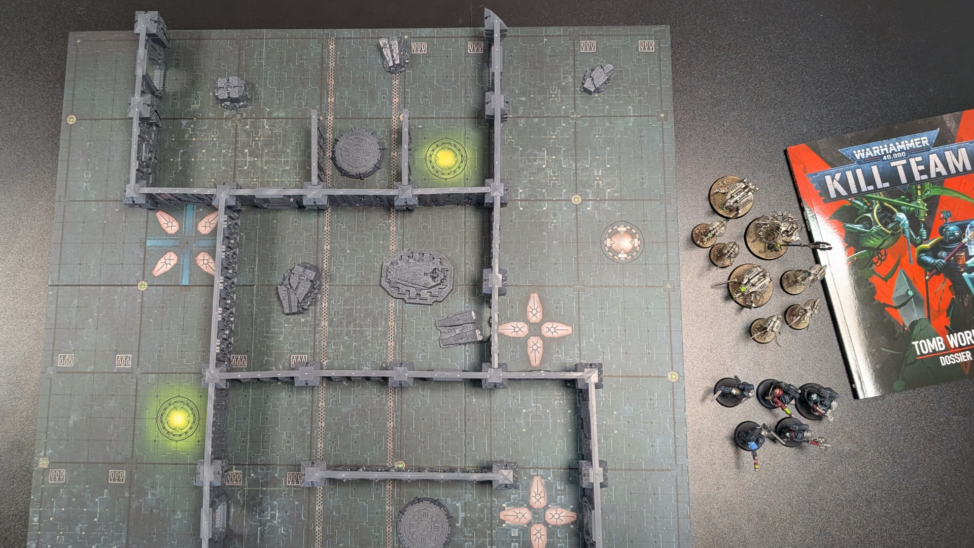 Kill Team: Tomb World board, terrain, miniatures, and book on a dark surface