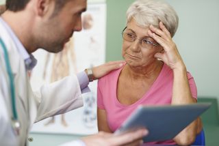 A doctor puts a hand on an upset patient's shoulder