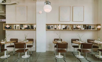 Restaurant featuring wooden tables and brown leather seats, tiled walls with a shelf running the length of the wall