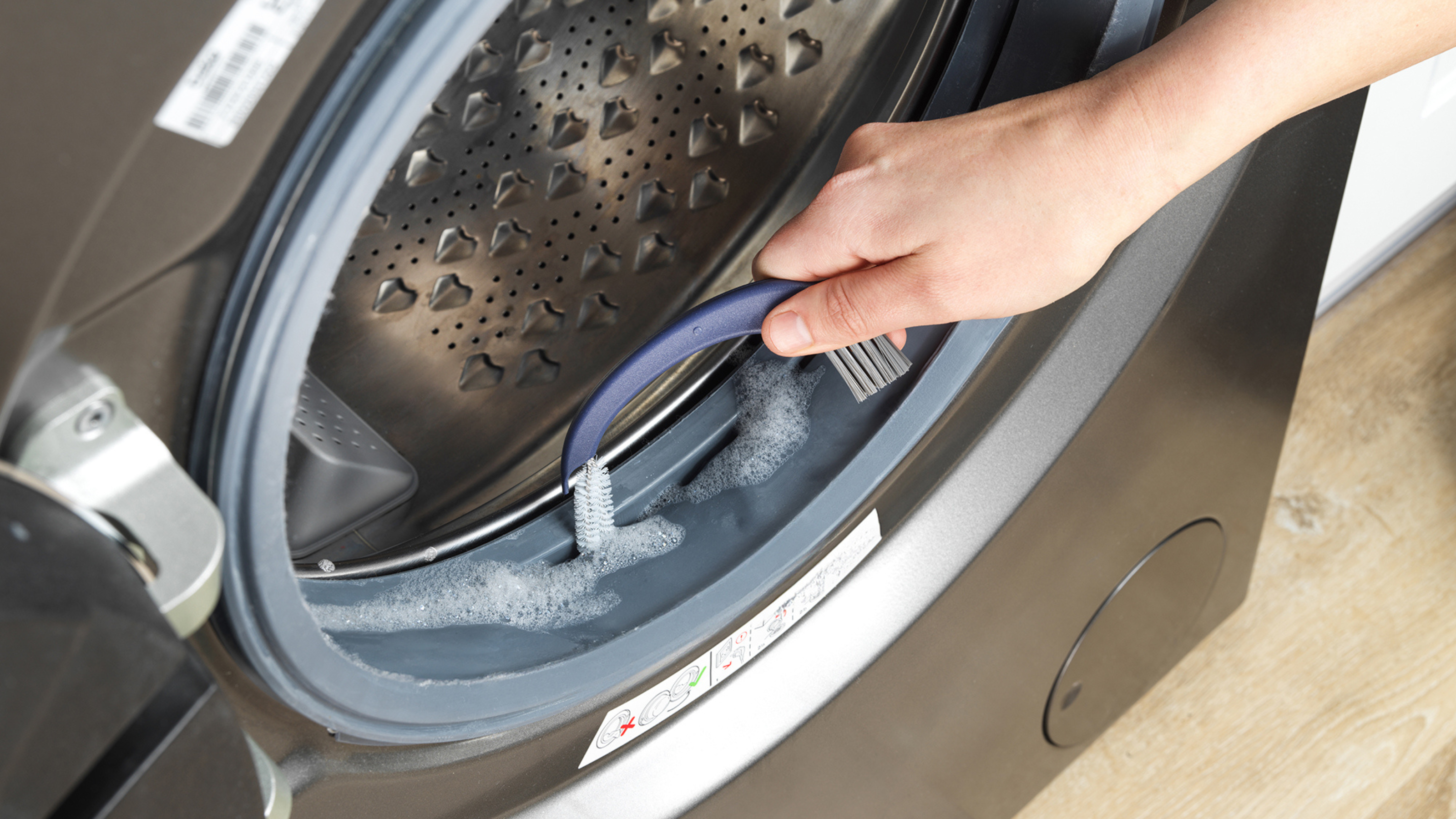 Deep Clean 3 in 1 Track Brush being used on washing machine seal.