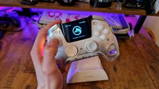 A reviewer holding the Manba One controller