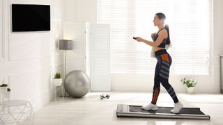 Woman using a walkingpad in front of TV