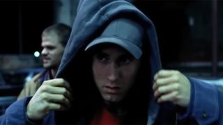 Eminem throwing a hoodie on in a scene from 8 Mile's trailer.