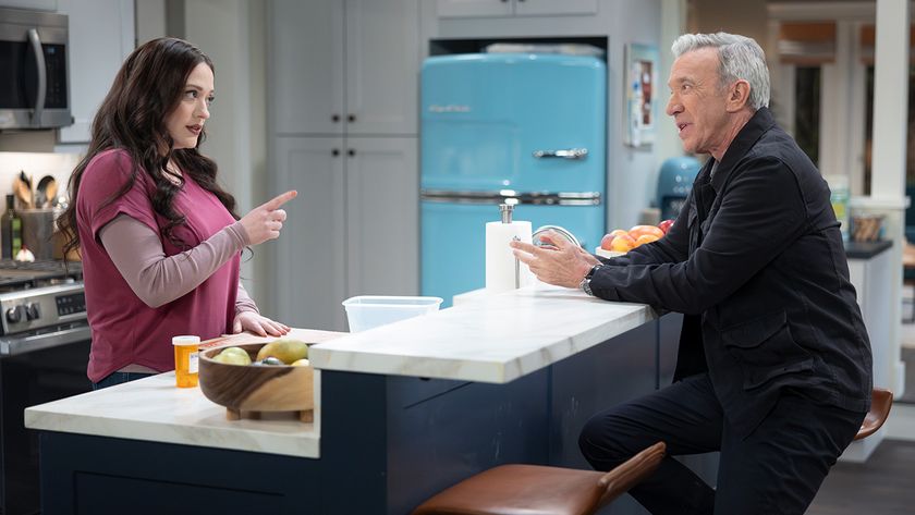 Tim Allen and Kat Dennings sparring verbally in the kitchen next to big blue fridge.