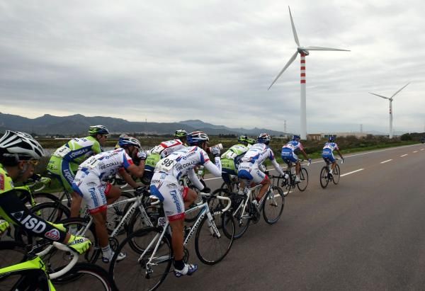 The peloton pass a wind farm on Sardegna
