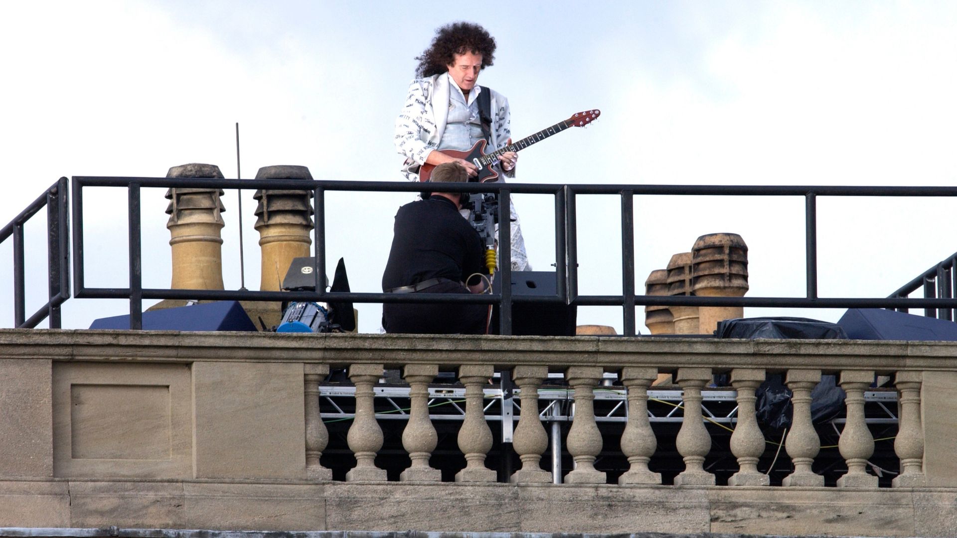 Brian May playing guitar on the roof of Buckingham Palace