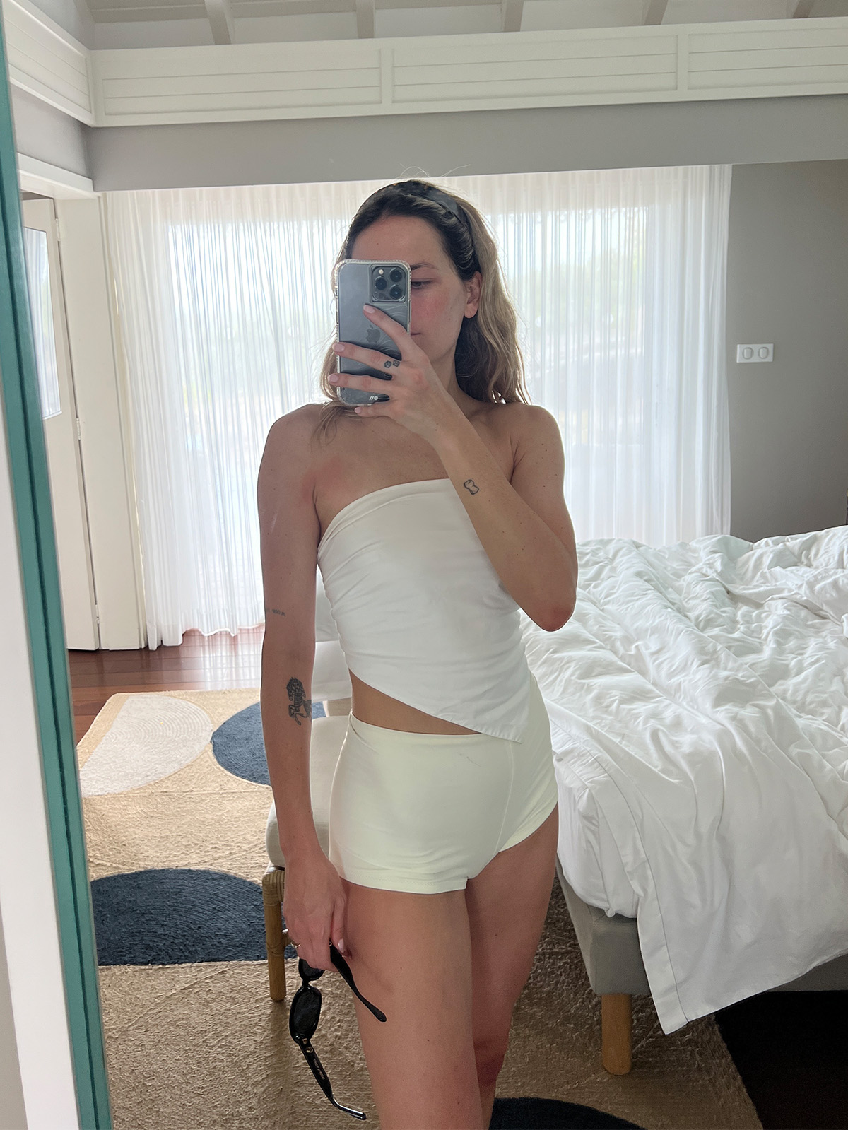 Eliza Huber wearing a Tibi bandana top with swim shorts.