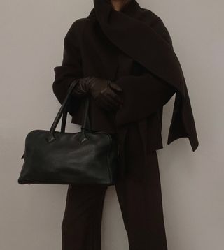 woman in brown coat with large tote bag